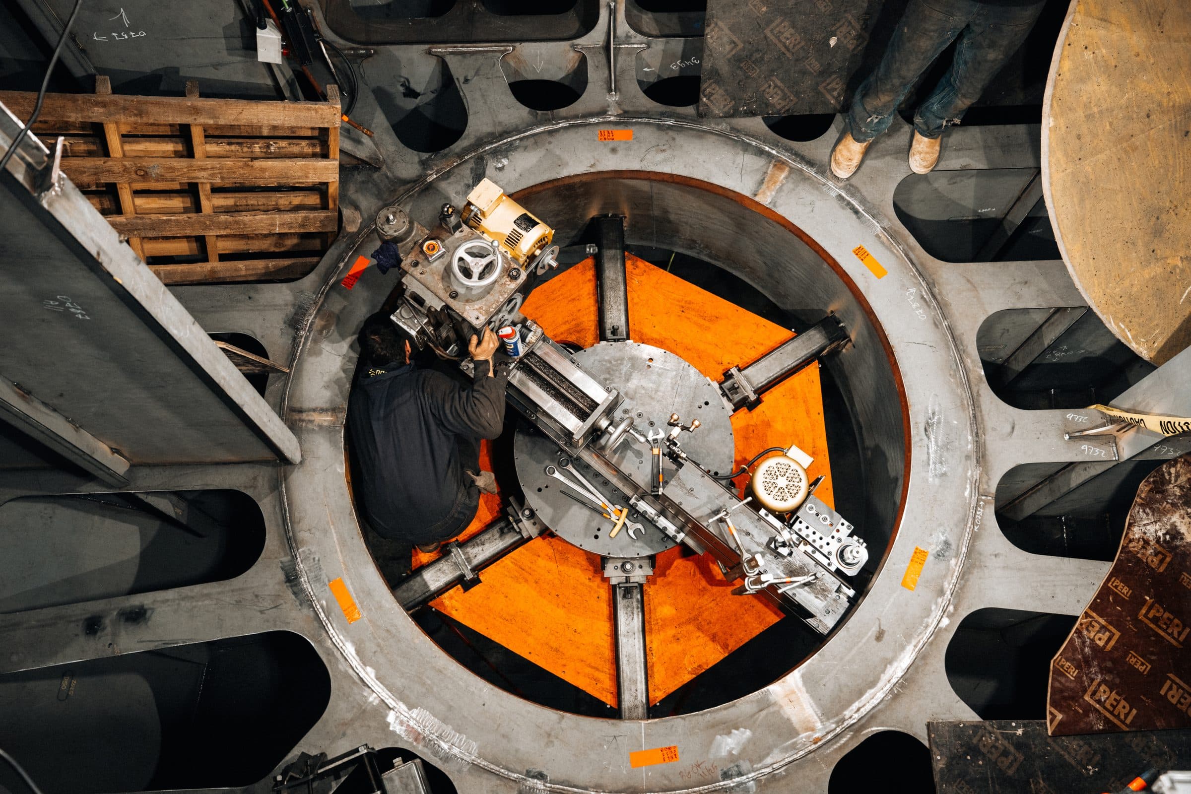 Technician operating pipe beveling machine inside Tuuli C’s thruster trunk.