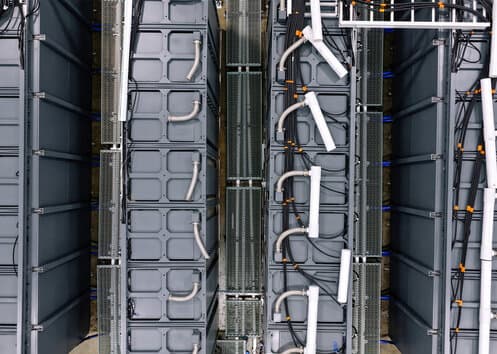 Rows of Arc battery cabinets with cooling lines and cabling.