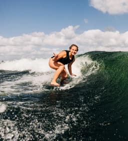 A photograph of a woman surfing the waves.