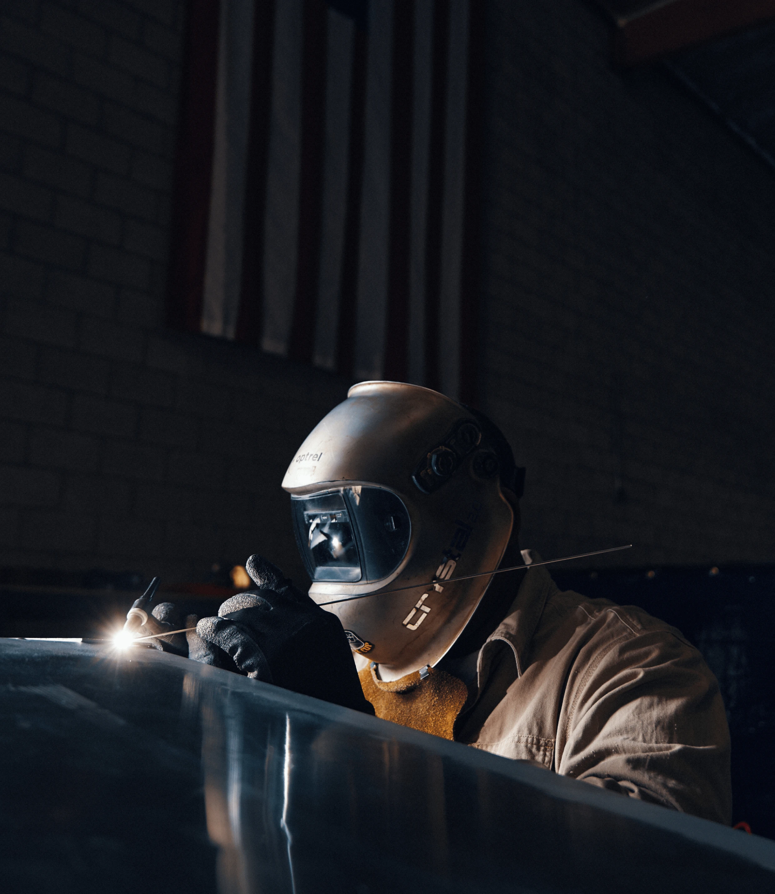 An engineer precisely welding part of the Arc One in the factory
