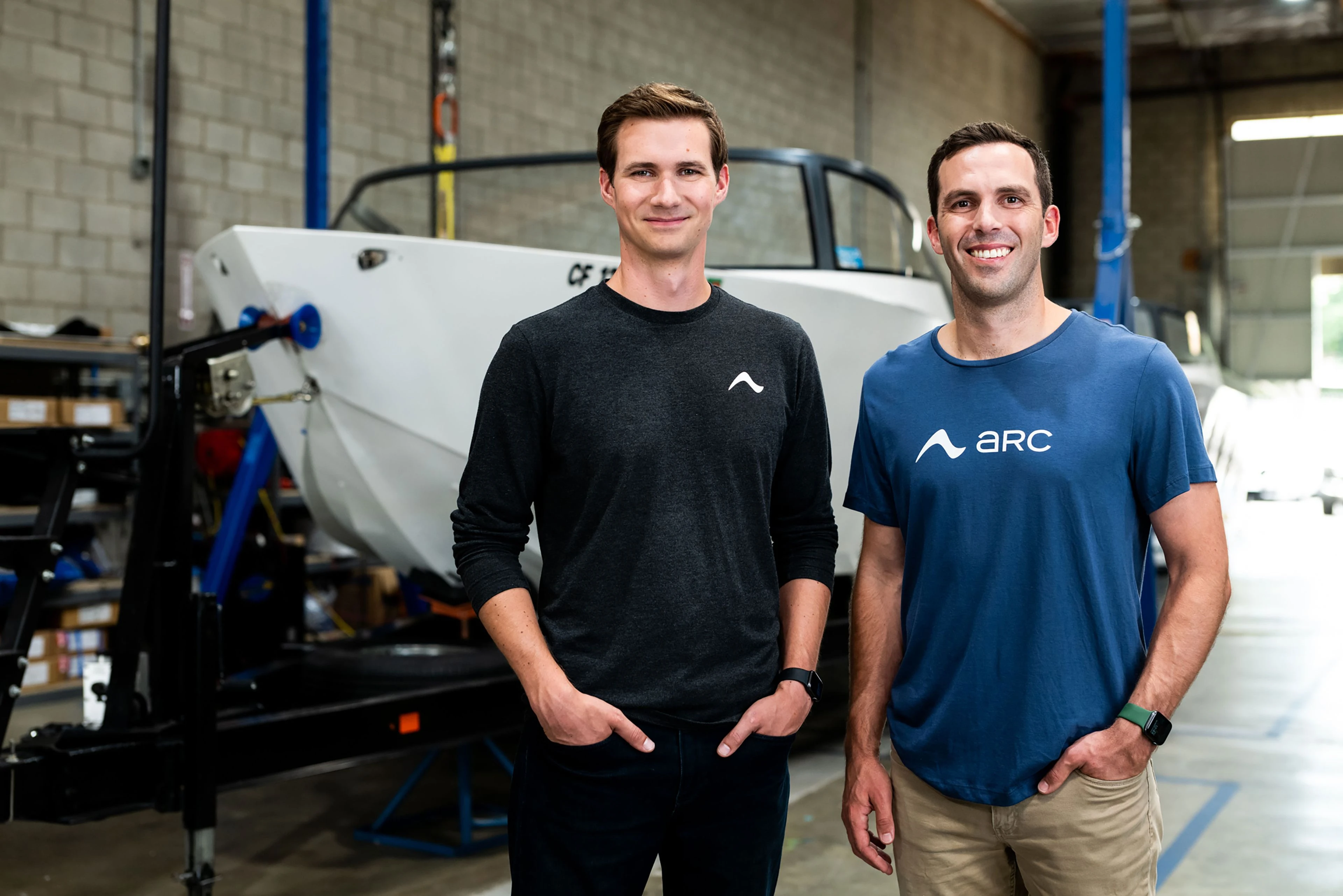 Ryan Cook and Mitch Lee, Arc's co-founders, standing in front of a boat